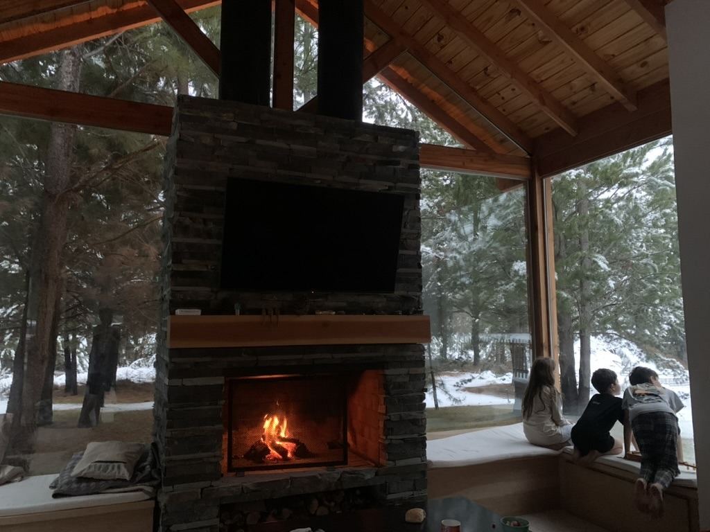 Living con hogar a leña y nieve afuera